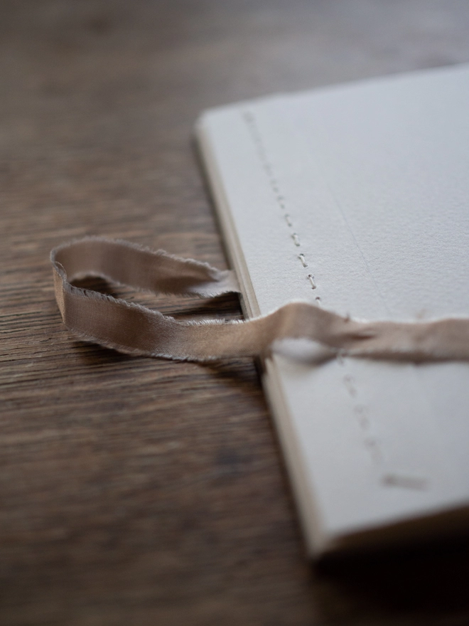 Close-up of ribbon tie and stitching on hand-bound concertina album