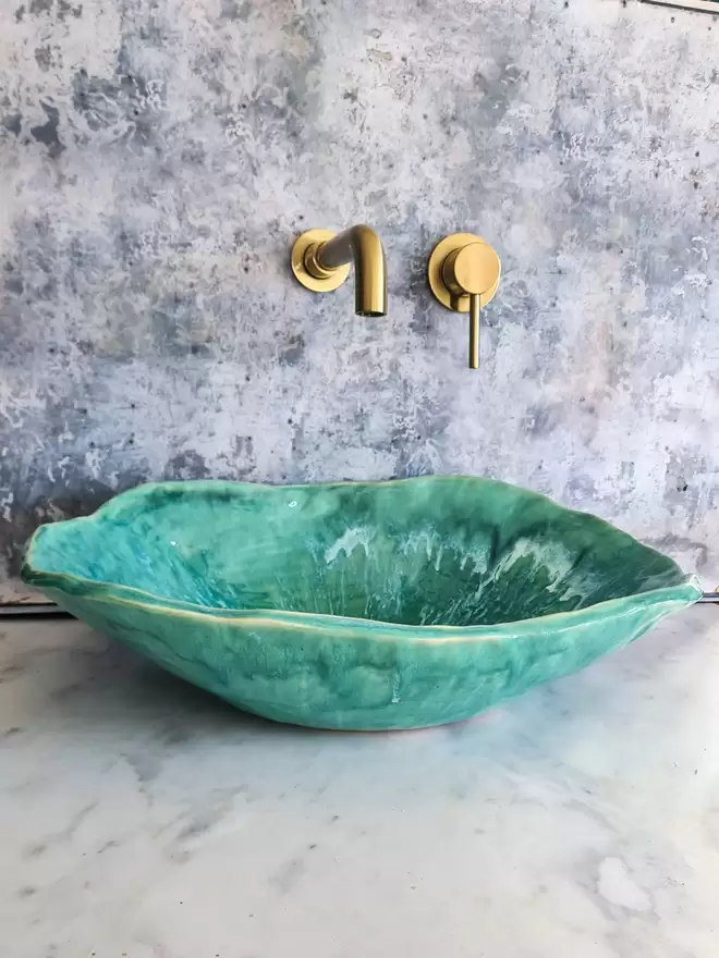 Turquoise green bathroom basin atop a marble countertop with gold taps, bathroom, wc, ensuite, sink, ceramic basin, Jenny Hopps Pottery, J.Hopps Pottery, J.H Pottery, Homeware, Bathroom decor, interior design, front view