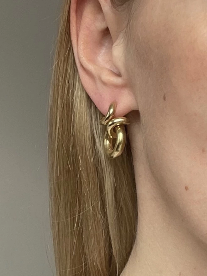 Shot of a model wearing a contemporary gold drop earring