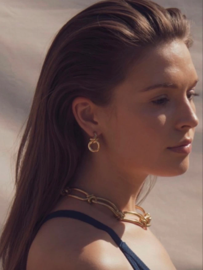 A model wearing the gold rollo hoop earrings and handmade bespoke chain necklace