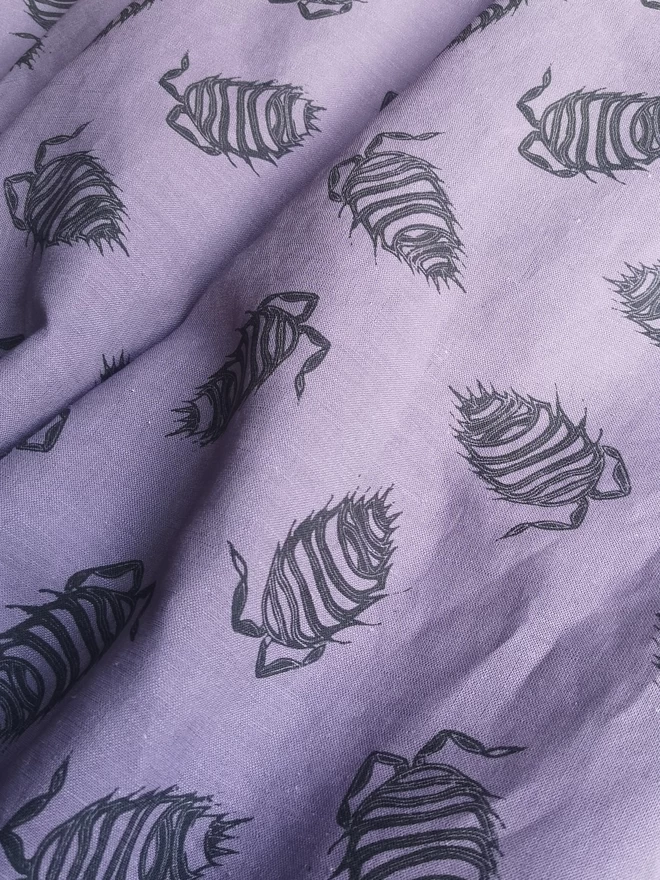 Cotton linen purple fabric with a charcoal woodlouse print.