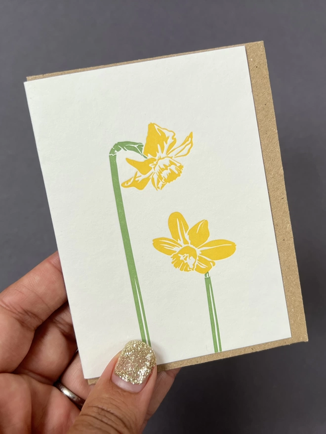 Bright yellow daffodil flowers on front of little card