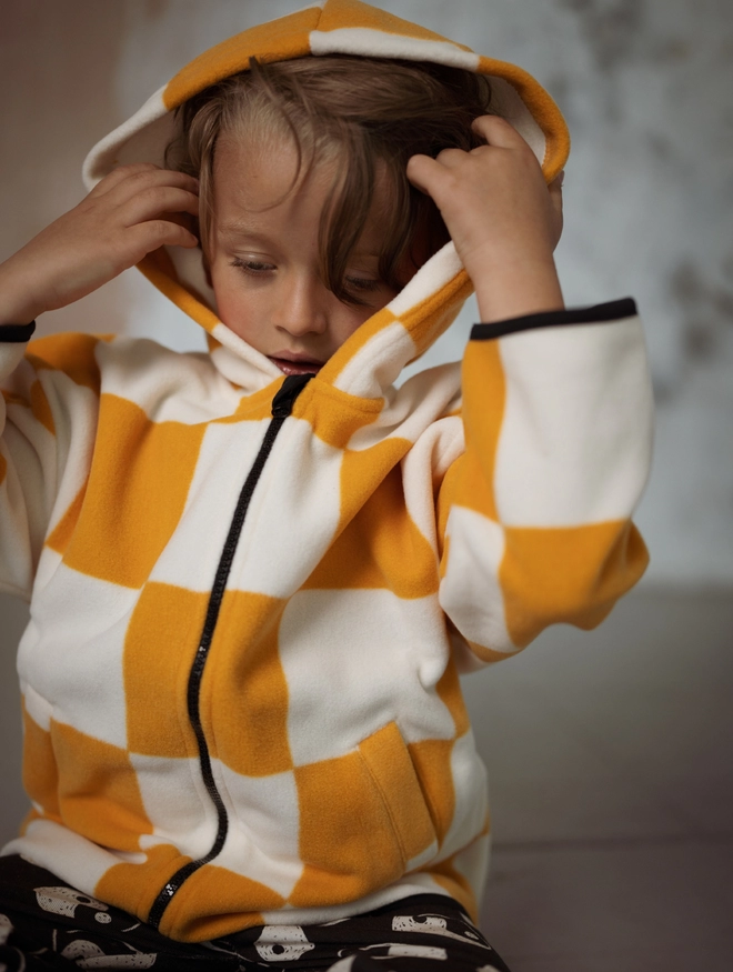 Another Fox Orange Checkerboard Polar Fleece Kids Hoody seen on a child with the hood up.