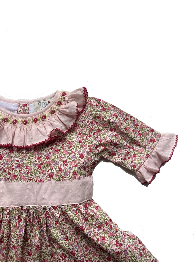 a floral dress with a pink frill collar and hand embroidered detailing