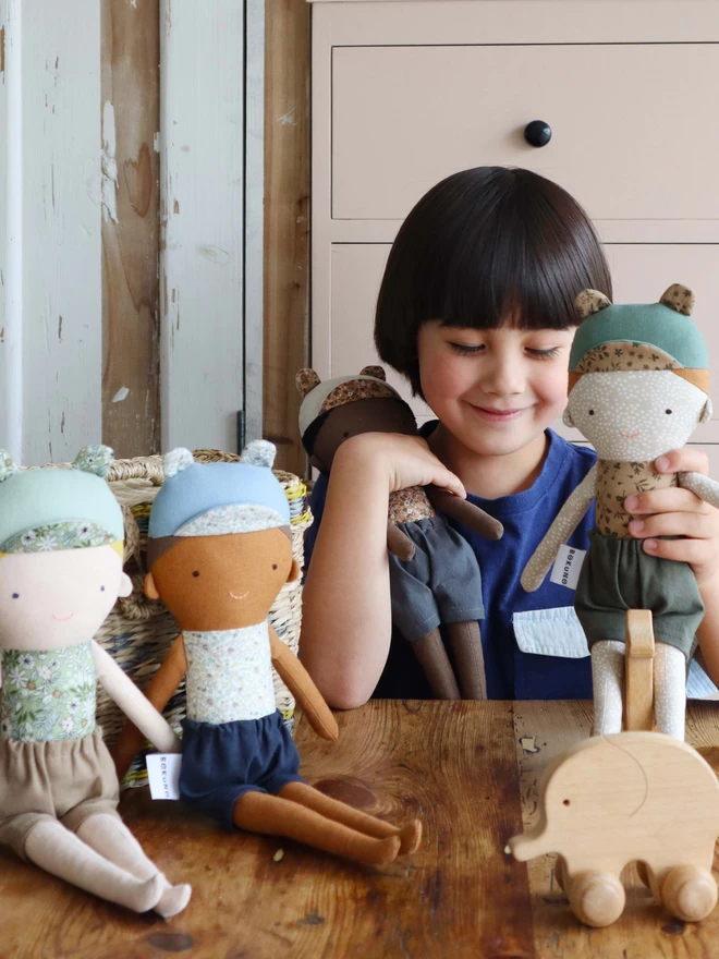 A child playing with boy dolls with diverse skintones