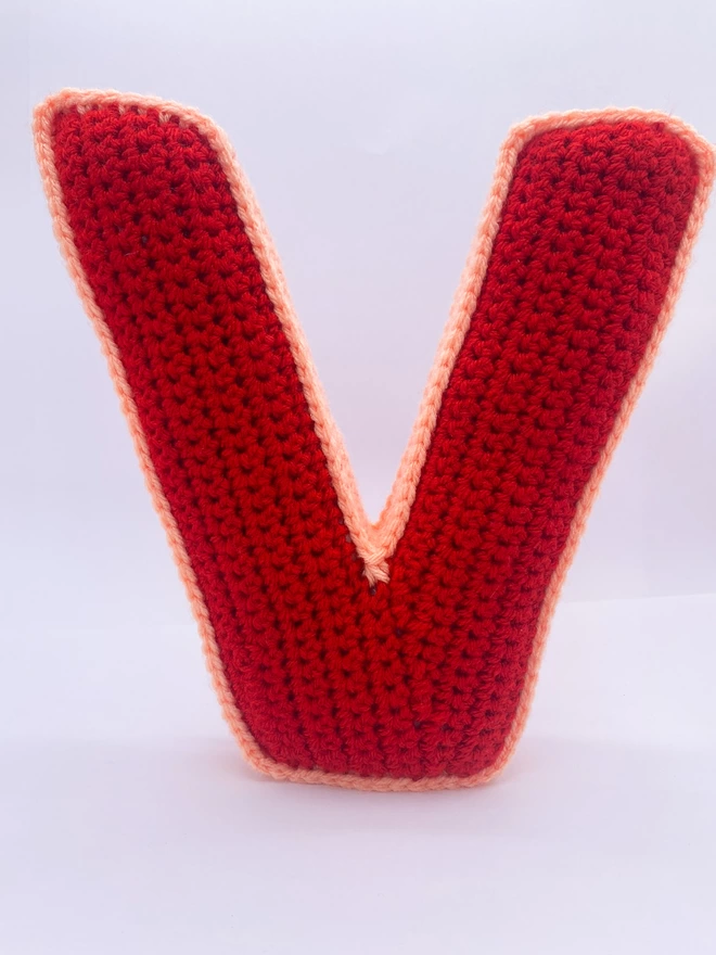 V shaped crochet cushion in red and peachy pink