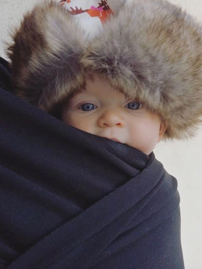 Baby wearing winter trapper hat in moose wave print