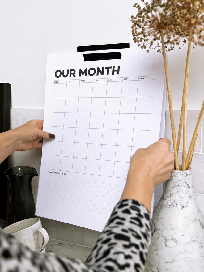 Close up of a lady pulling a Year Wall Planner page off.
