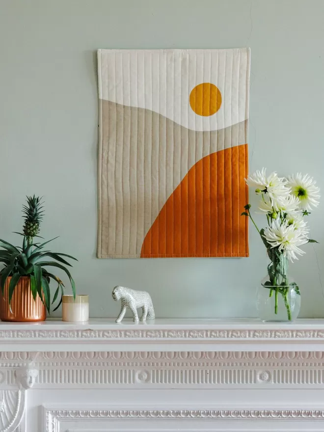 Sunrise Quilt Hanging Above Fireplace