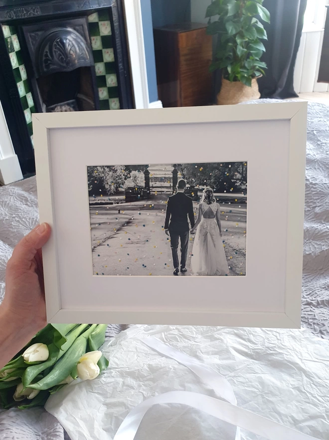 Wedding photo with hand embroidered confetti held in white frame