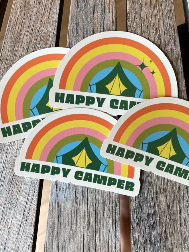 Happy Camper rainbow vinyl stickers on a wooden table