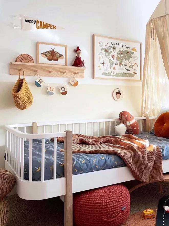 Fun kids room, gorgeous children's decor. A solid wood pegrail shelf sits above the bed