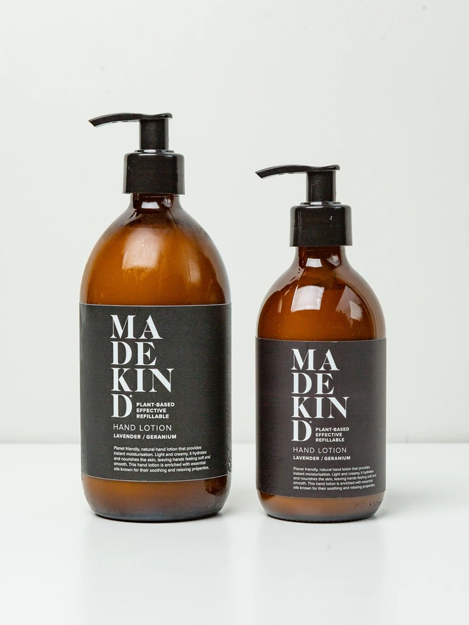 Two sizes of natural, luxury hand lotion in refillable amber glass bottles