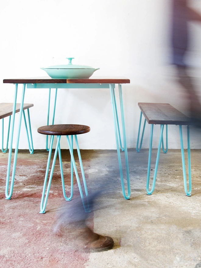 end view of a hairpin leg dining set with table, benches and stool with walnut wood tops and turquoise hairpin legs