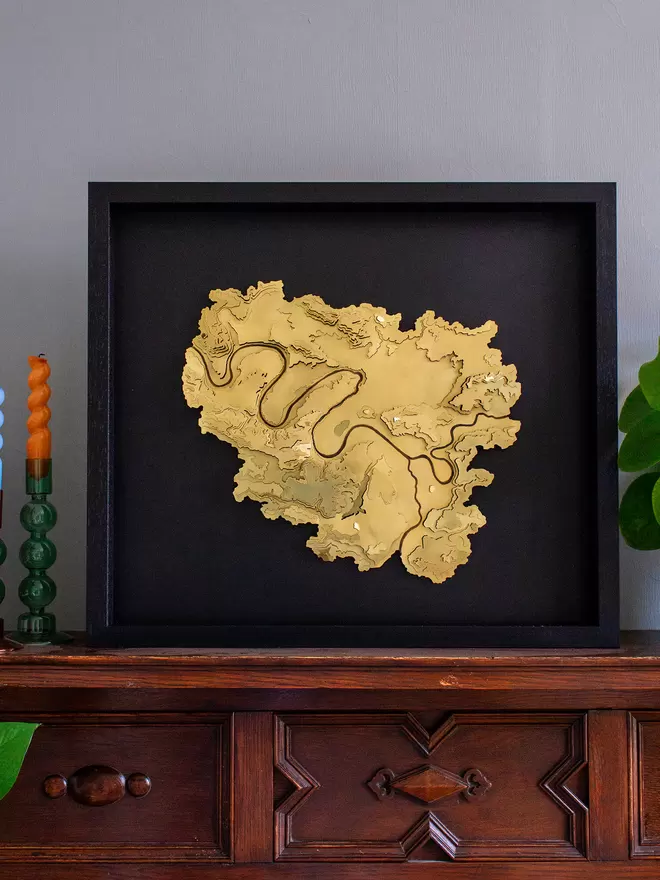 Golden brass coloured metal contour map wall piece of Paris in a black frame with black backrgound