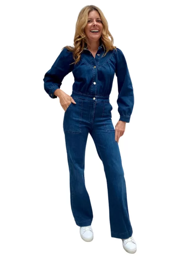 The Maggie Denim Jumpsuit worn by the model smiling