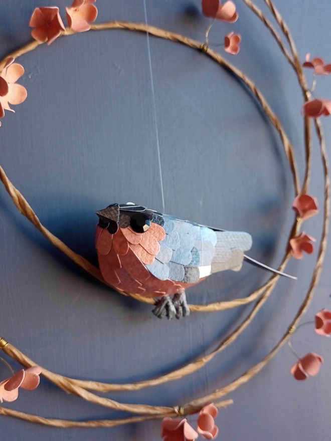 Close up of a paper bullfinch sculpture.