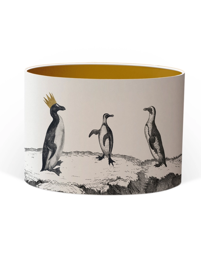 Drum Lampshade featuring a parade of penguins with a Gold inner on a white background