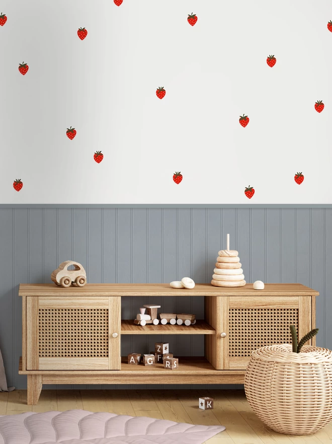 Strawberry wall stickers in playroom with blue grey wall panelling and wooden toys
