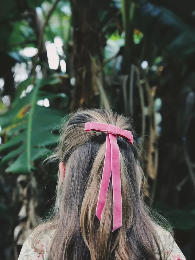 Child outside wearing the Velvet Hair Bow in ballet pink.