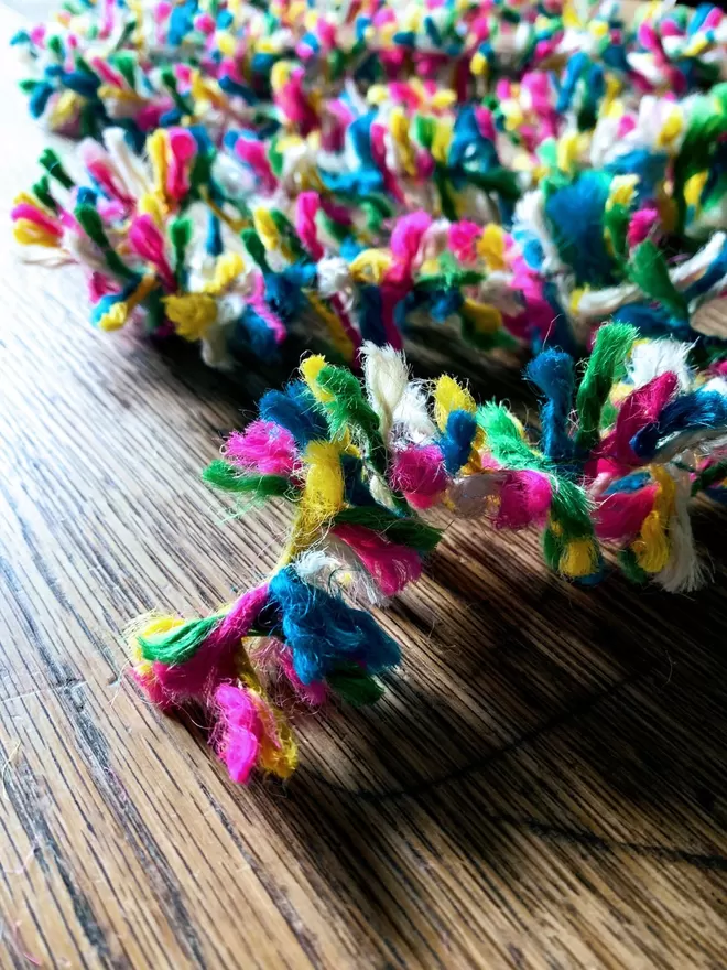 Close up of multicolour neon jute string tinsel AKA Strinsel on an oak table